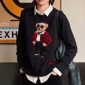 Polo Ralph Lauren Wearing sunglasses and a black sweater with a bear pattern